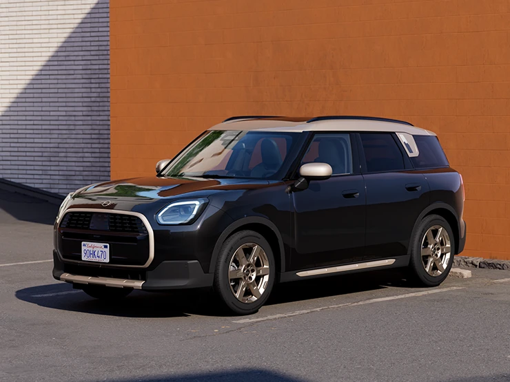 MINI Countryman in Midnight Black II with a White roof parked beside an orange wall.
