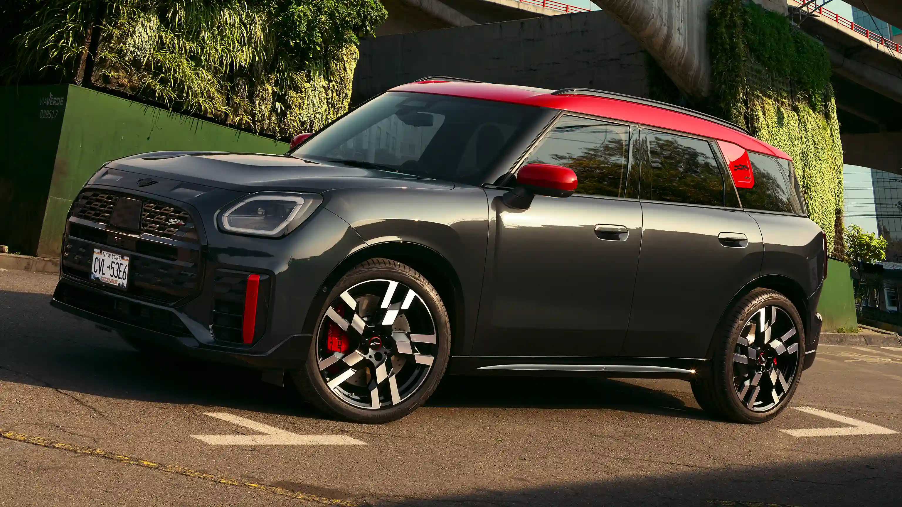 MINI Countryman John Cooper Works in Midnight Black II with Chili Red roof parked on an urban street.